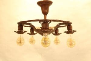 Vintage chandelier with exposed light bulbs.