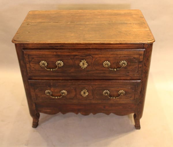 Vintage wooden dresser with ornate handles.