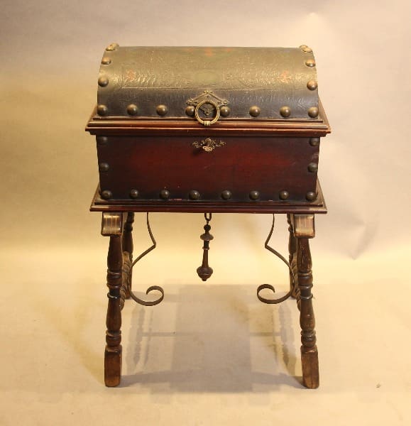 Antique chest on ornate wooden stand.
