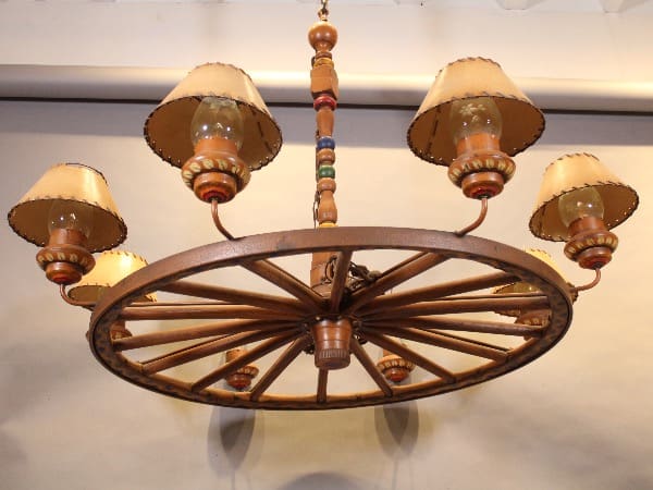 Rustic wagon wheel chandelier with six lamps.