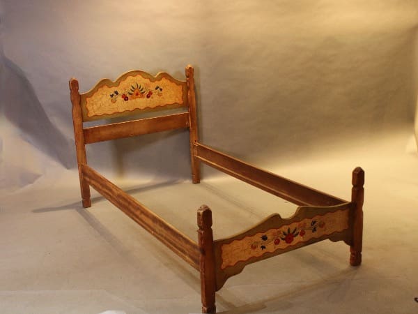 Wooden bed frame with floral decorations.