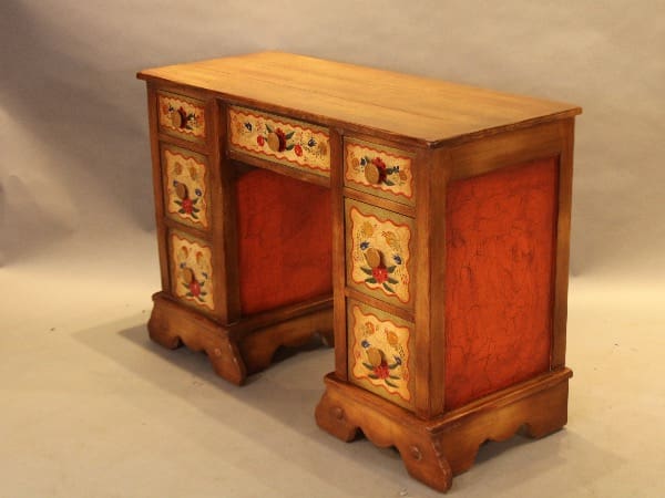 Ornate wooden desk with painted floral designs.
