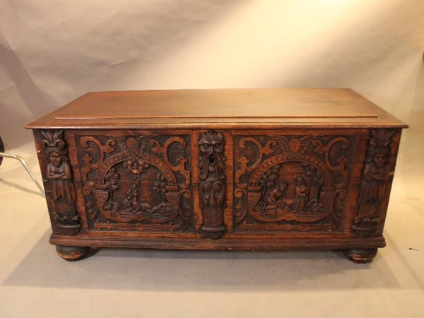 Ornate wooden chest with carved figures.