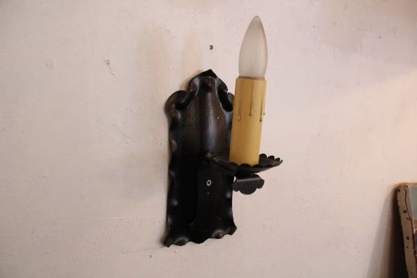 Vintage wall sconce with candle-shaped bulb.