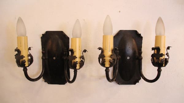 Vintage wall sconces with ornate black design.