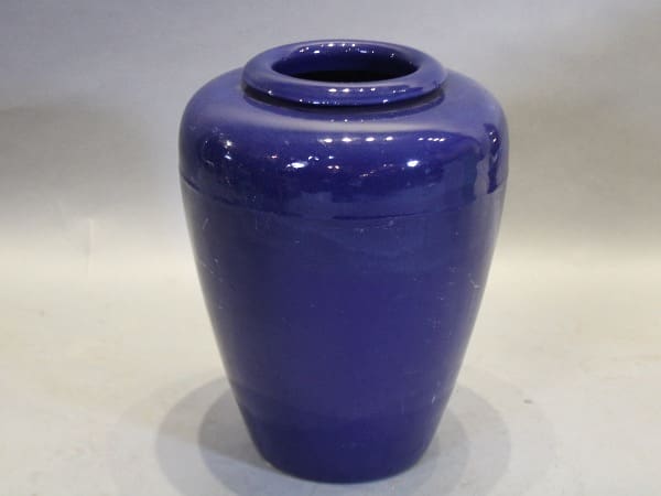 Blue ceramic vase on neutral background.