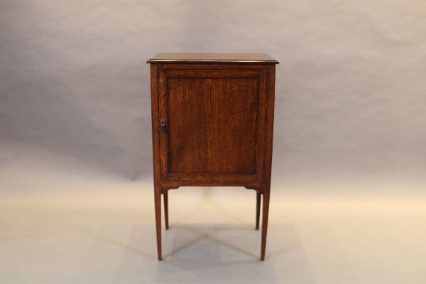 Wooden cabinet with single door and legs.