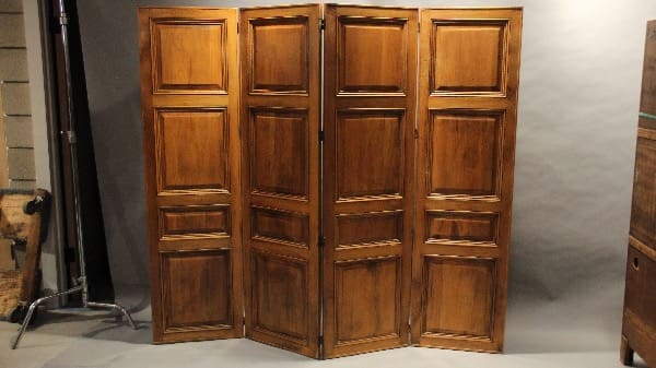 Wooden folding room divider with panels.