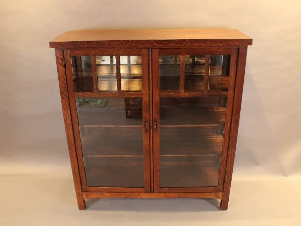 Wooden cabinet with glass doors and shelves.
