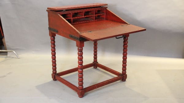 Antique red wooden writing desk with compartments.