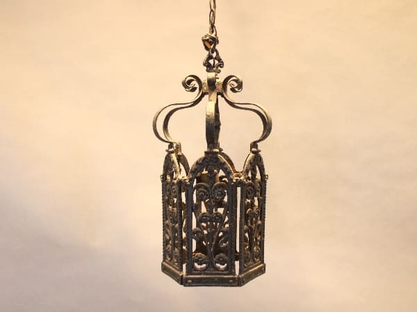 Ornate vintage metal lantern against beige background.