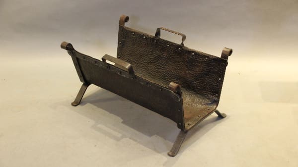 Antique metal log holder with handles.
