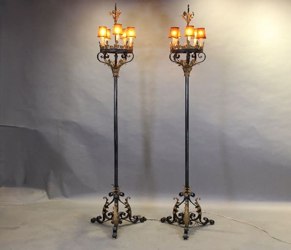 Two ornate iron floor lamps with lights.