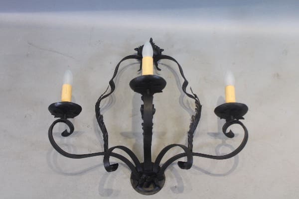 Vintage three-arm wall sconce with bulbs.