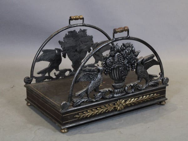 Ornate metal magazine rack with decorative design.