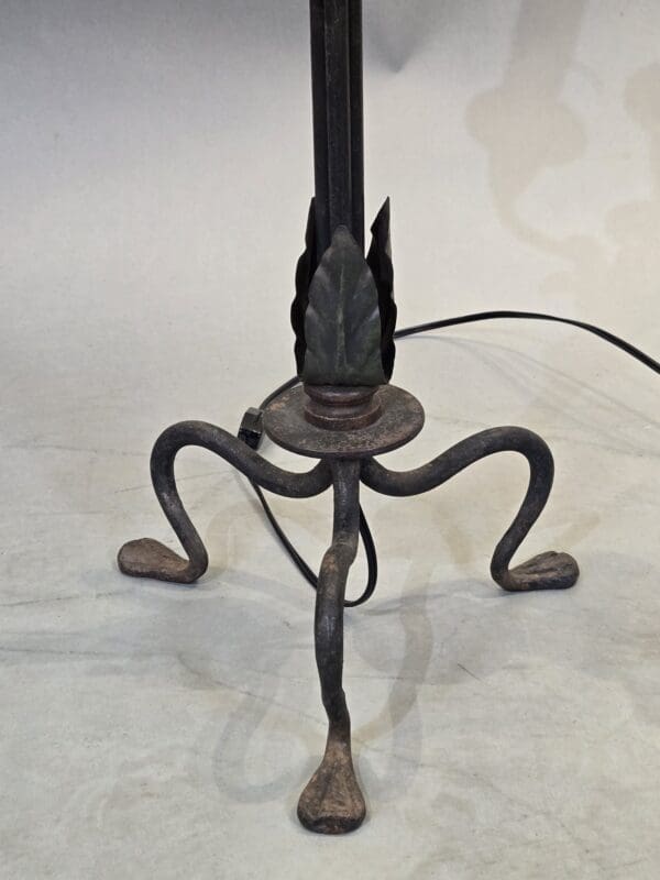 Wrought iron lamp base with three legs.