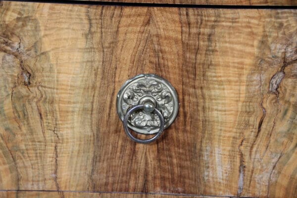 Wooden cabinet with ornate metal handle.