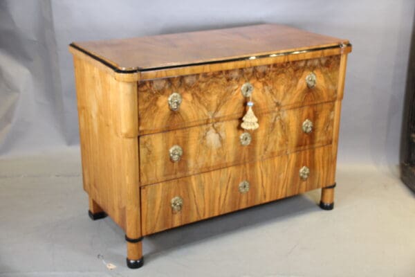 Wooden dresser with ornate drawer handles.