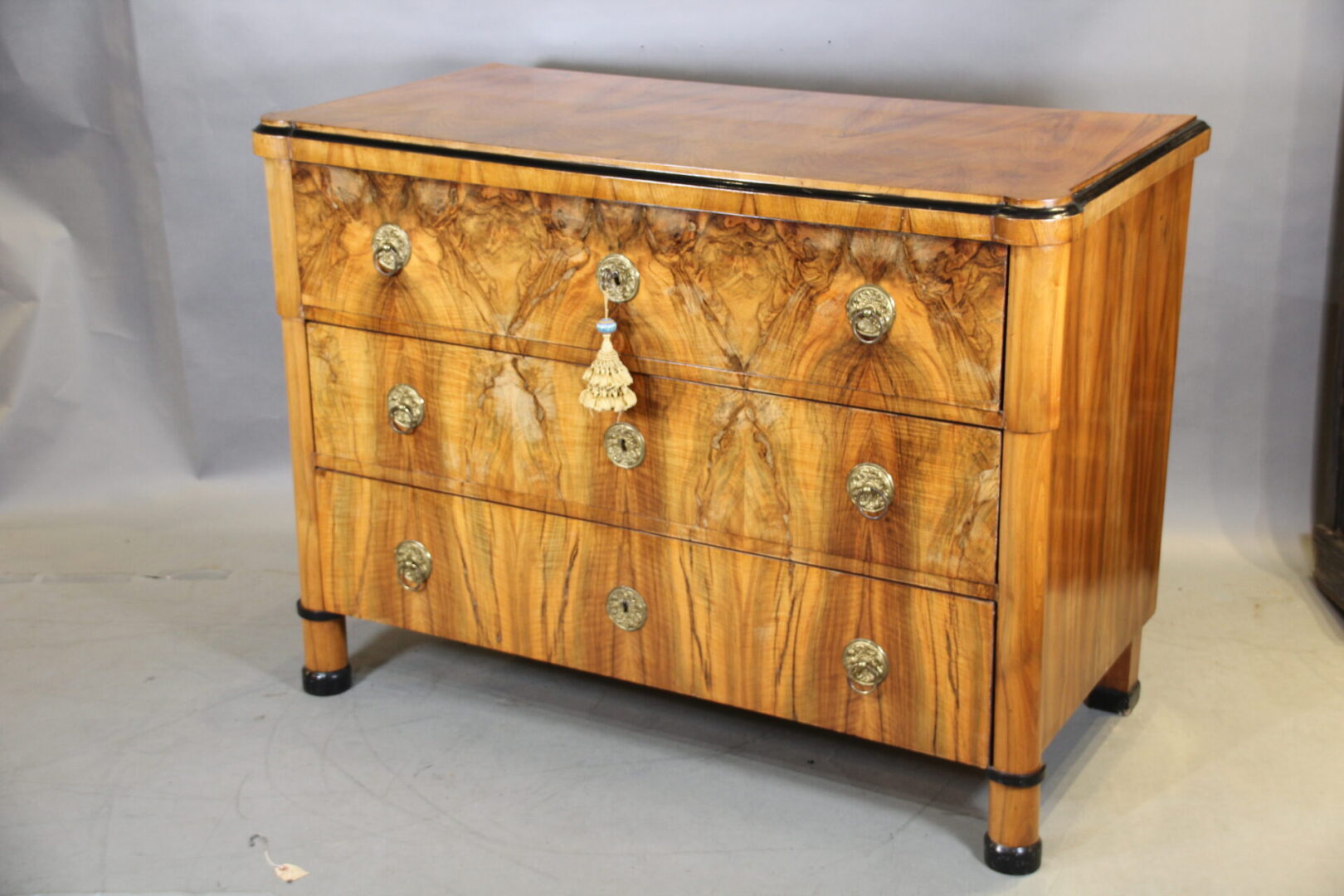 Wooden chest of drawers with decorative knobs.