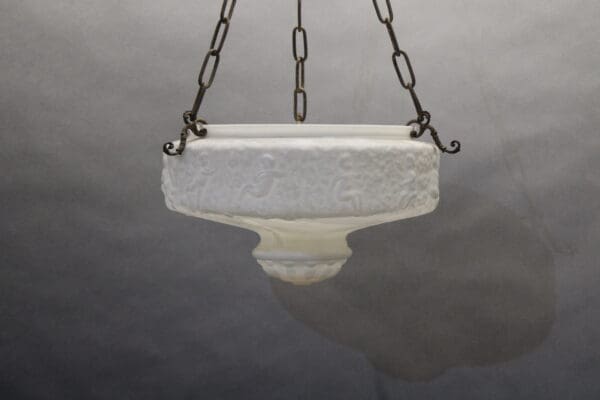 Hanging white decorative bowl on chains.