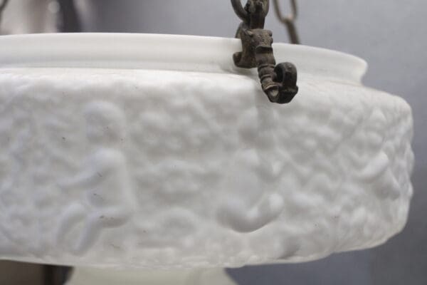 White embossed glass light fixture with chains.