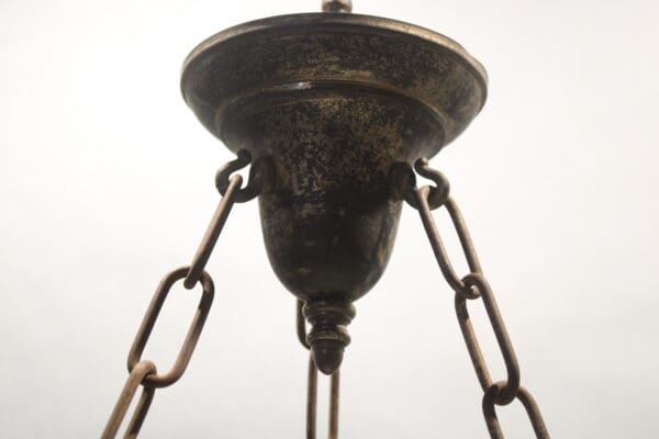 Rustic chandelier with metal chains and canopy.