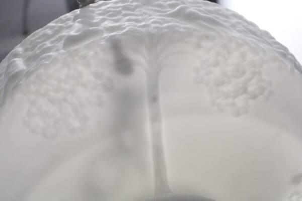 Embossed tree design on white surface.