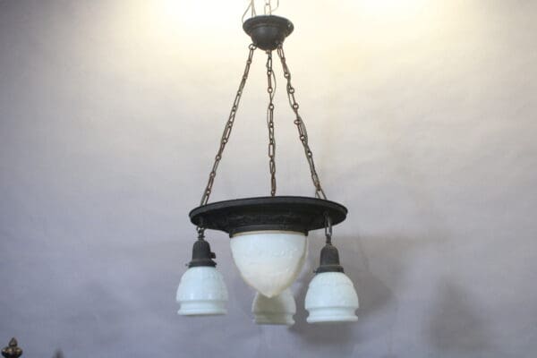 Vintage chandelier with white glass shades.