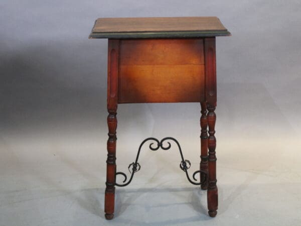 Wooden table with ornate metal legs.