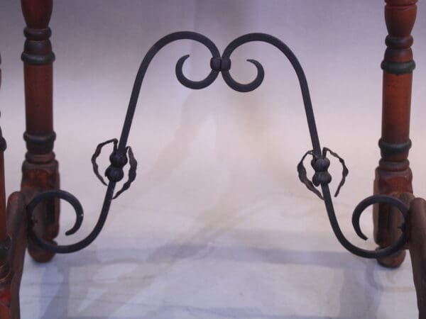 Ornate metal fireplace andiron with scroll design.