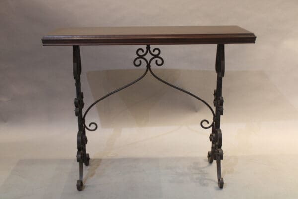 Ornate wooden table with iron legs.