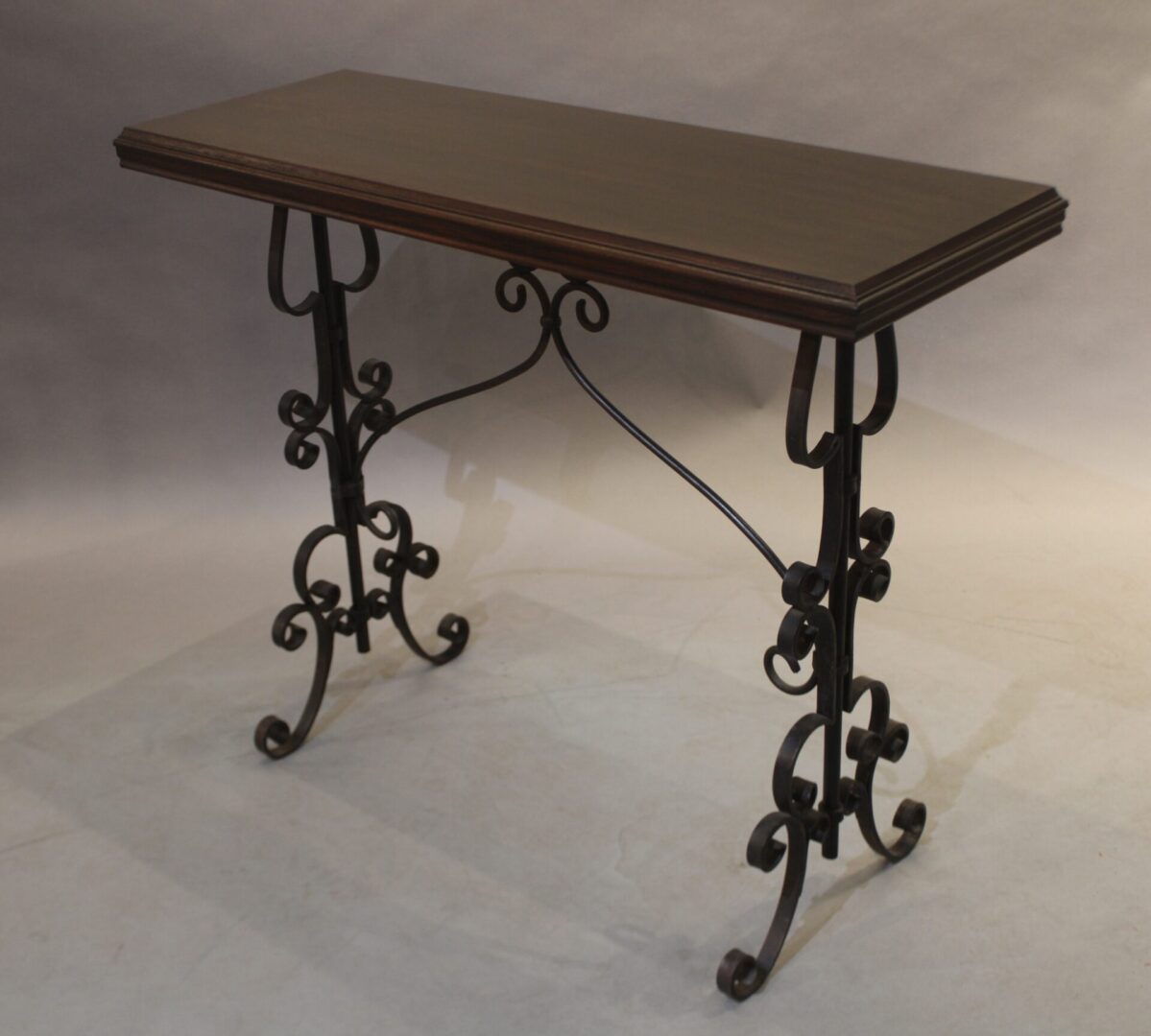 Decorative console table with wrought iron legs.