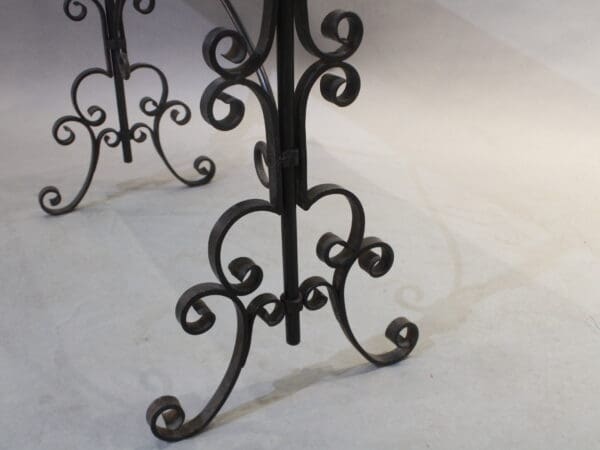 Ornate wrought iron table legs on floor.