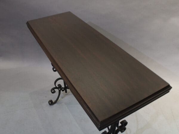Dark wooden table with ornate metal legs.