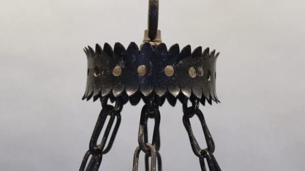 Metal chandelier with black chains and spikes.
