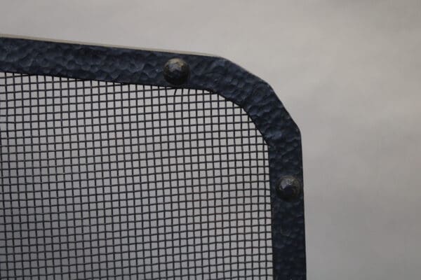 Metal mesh corner with rivets.