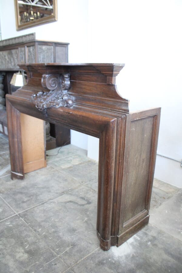 Antique wooden fireplace mantel in room.