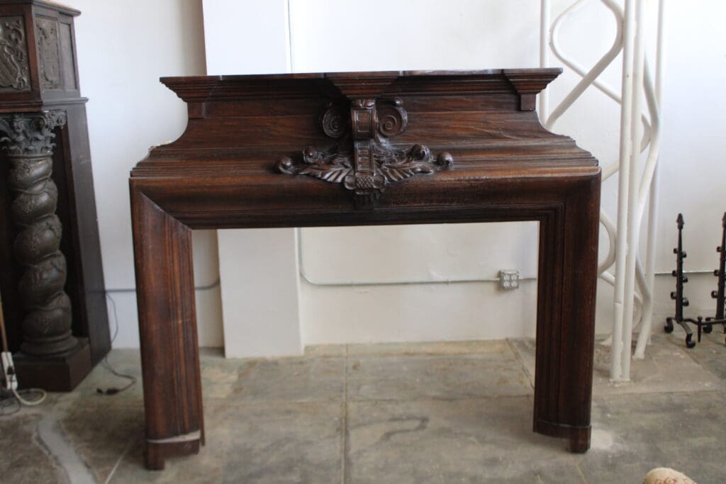 Ornate wooden fireplace mantel in a room.