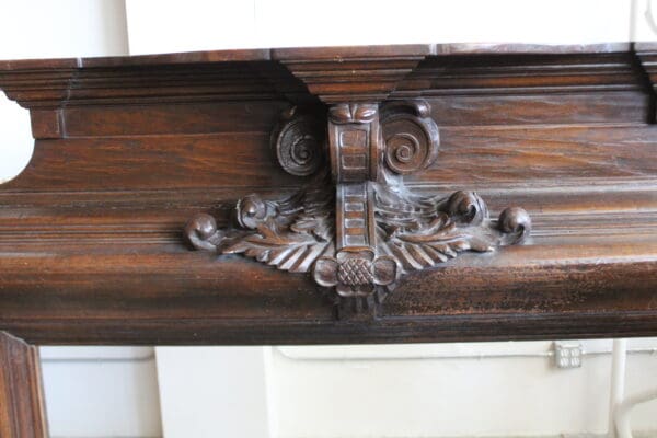 Ornate wooden fireplace mantel with carved details.