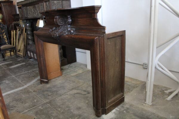 Ornate wooden fireplace mantel in storage.