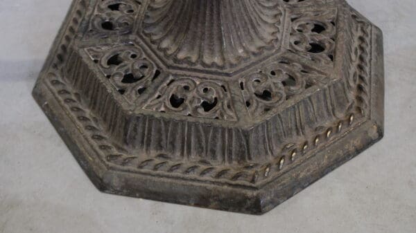 Ornate octagonal metal base on floor.