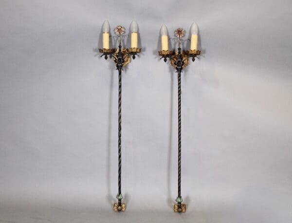 Two ornate antique wall sconces with bulbs.