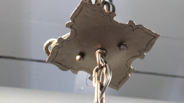 Ornate ceiling fixture with metal chain.