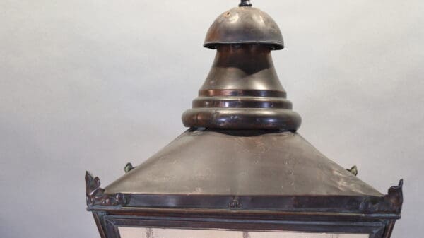 Vintage metal lantern against a gray background.