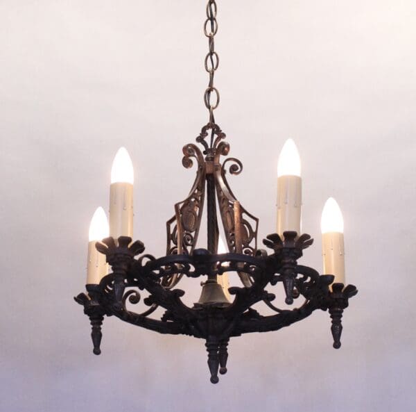 Ornate chandelier with five lit candles.