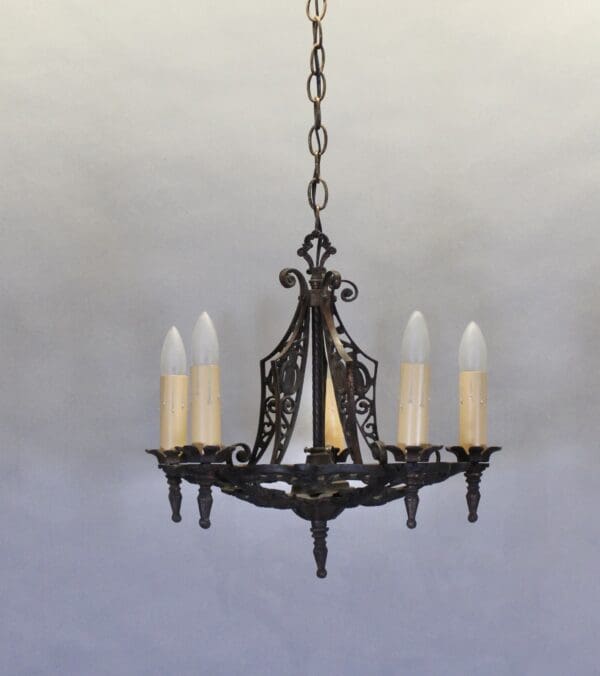 Vintage chandelier with five candle-style lights.