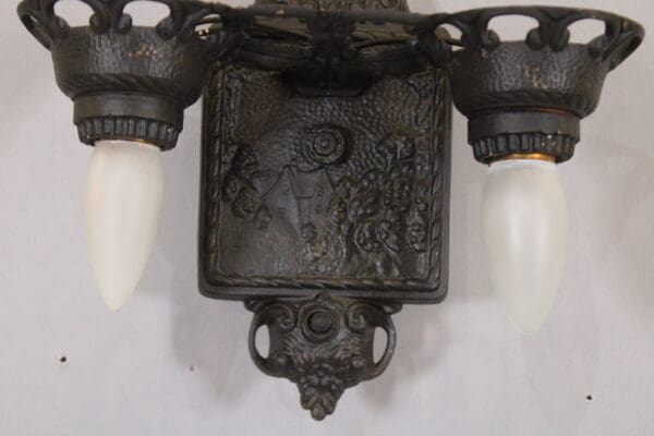 Ornate vintage wall sconce with two bulbs.