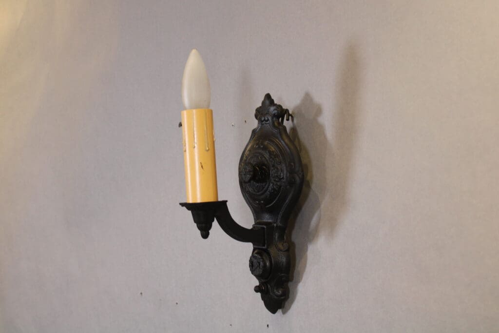 Vintage wall sconce with candle-shaped bulb.