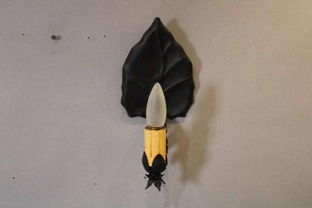 Wall-mounted light fixture with leaf design.