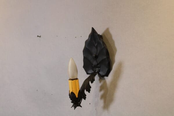 Wall-mounted decorative black candle sconce.